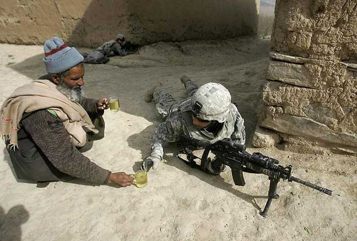 2. An Afghan man offers tea to soldiers