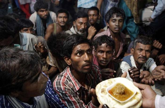 20. Indian homeless men wait to receive free food distributed outside a mosque ahead of Eid al-Fitr in New Delhi, India