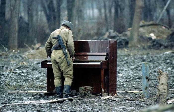 25. A Russian soldier playing an abandoned piano in Chechnya in 1994